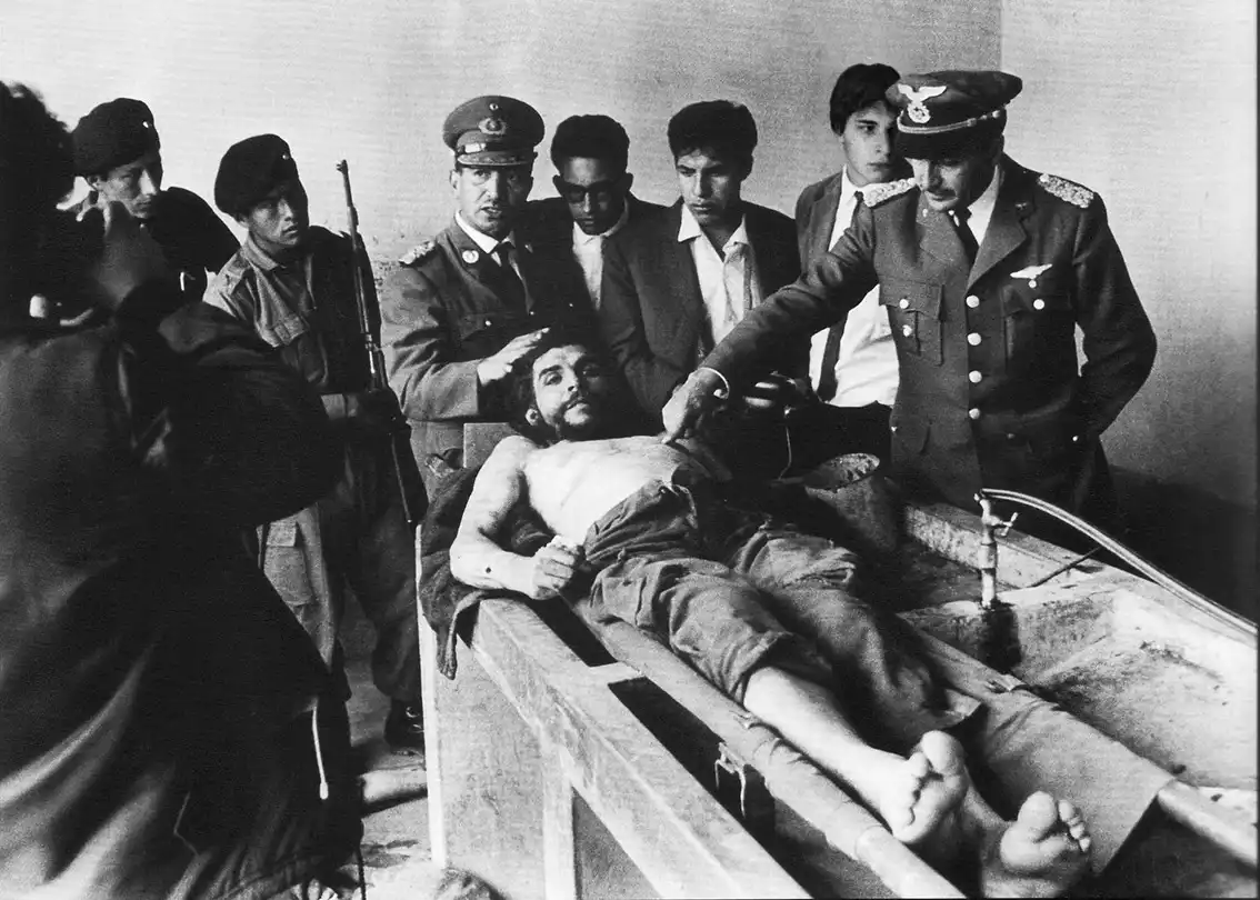 Fotografía de Che Guevara muerto sobre una mesa de madera.
