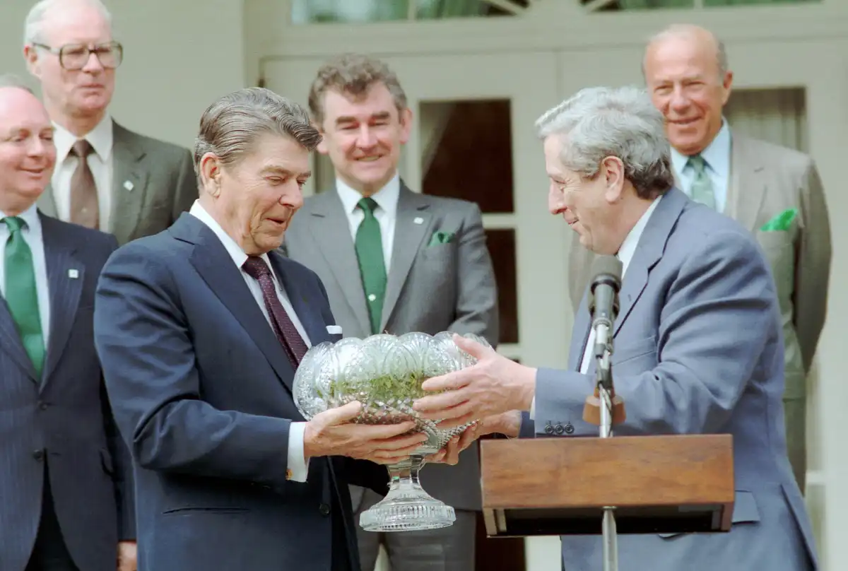 El presidente Ronald Reagan y George Shultz en la ceremonia en el Jardín de las Rosas con el primer ministro irlandés Garret FitzGerald para recibir tréboles en un cuenco de Waterford.