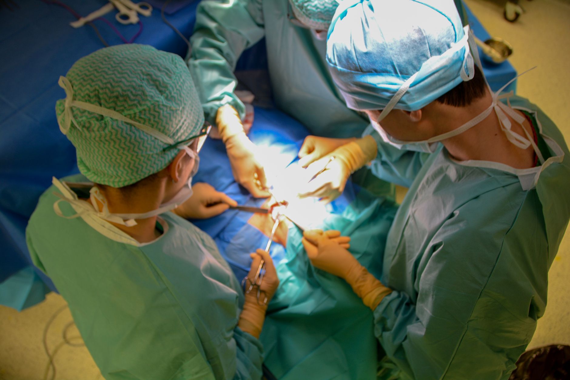 robotic surgery team performing kidney transplant modern operating room dramatic blue light