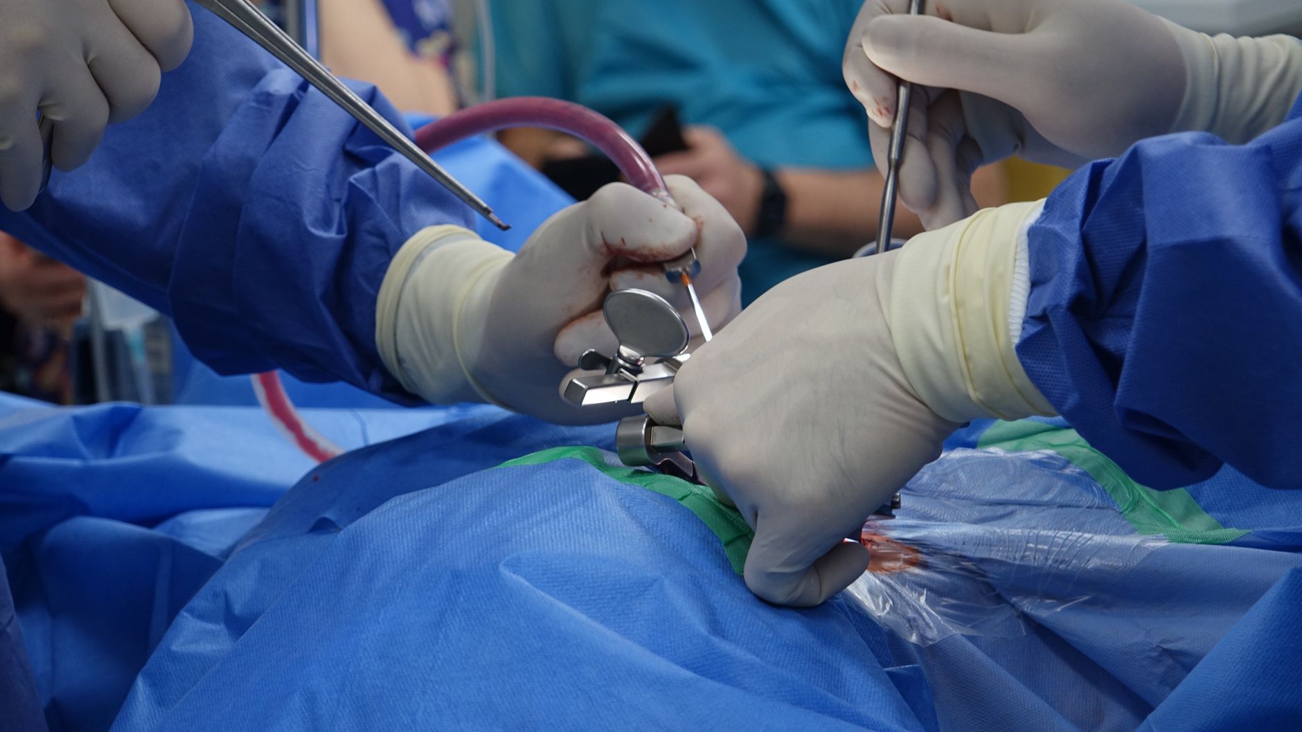 surgeon monitoring spinal nerve signals in operating room dramatic clinical lighting