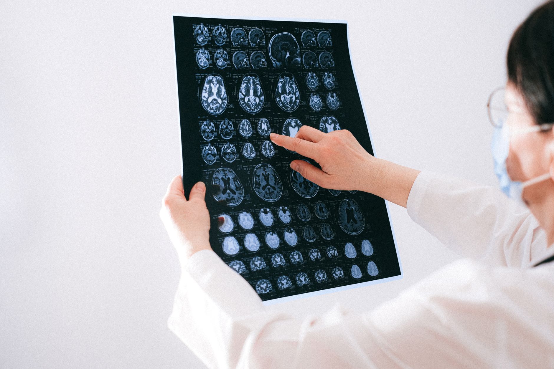doctor reviewing brain scan images on monitor in clinical office soft light