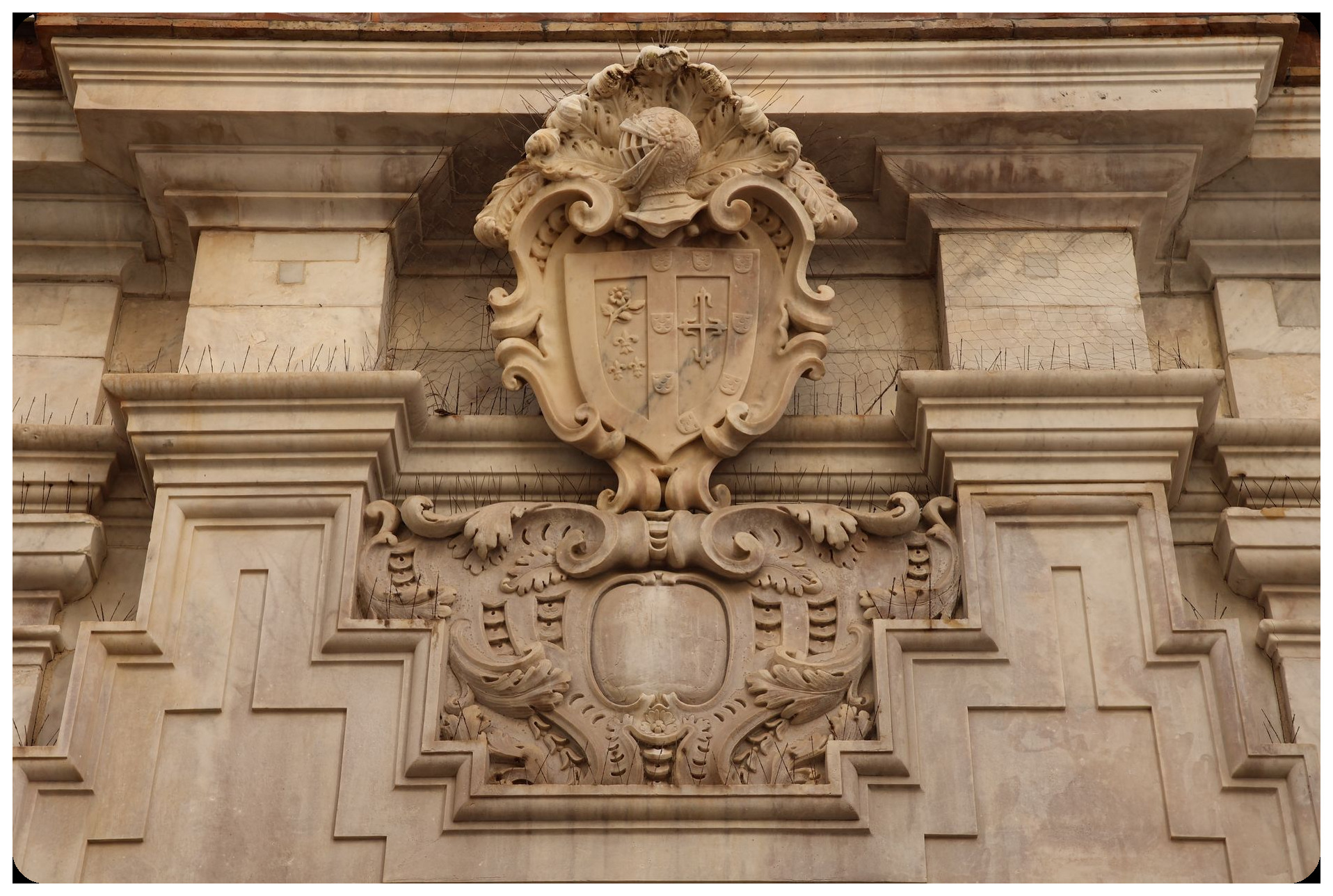 restoration technician using photonic laser equipment to carefully clean white alabaster carvings and decorative details on historical palace facade