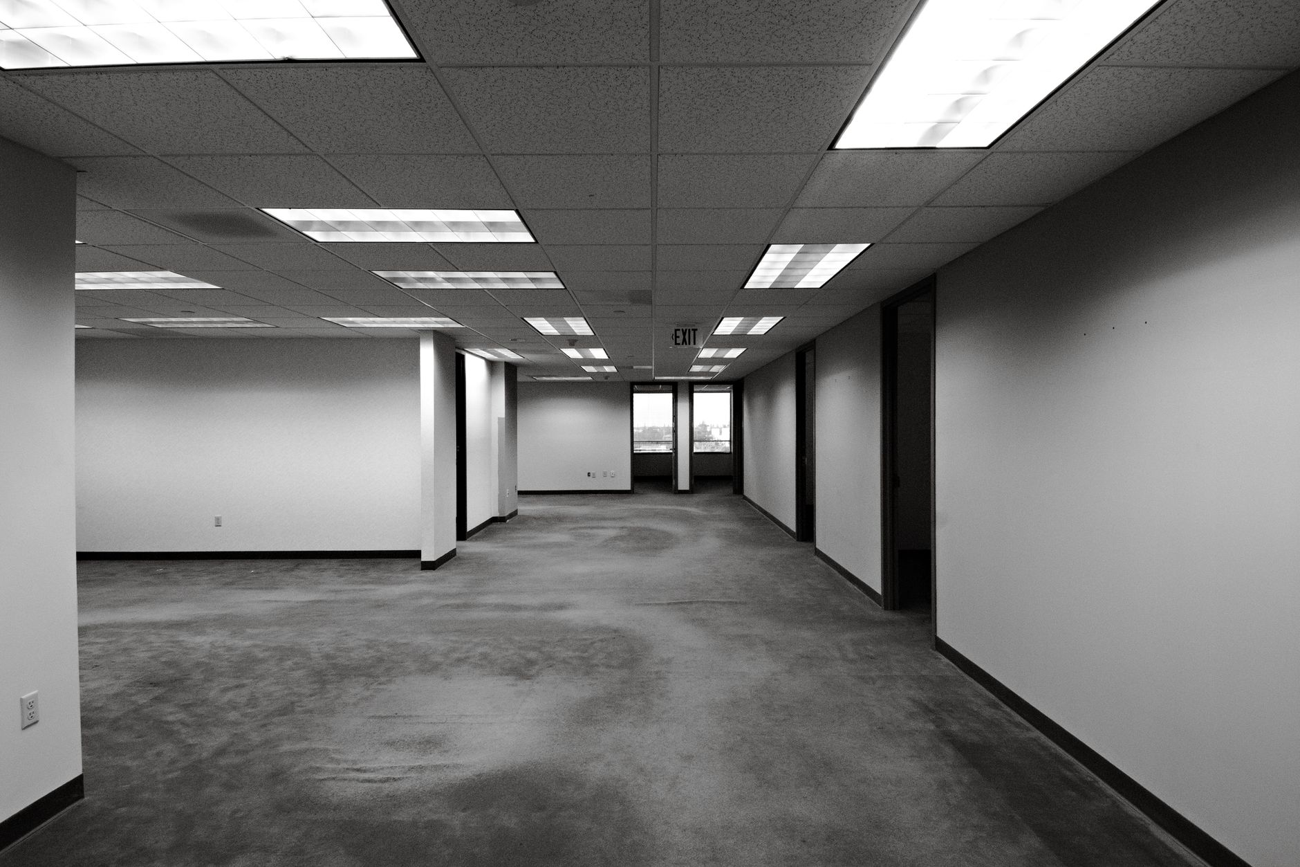 endless yellow fluorescent hallway with brown carpet and buzzing lights creating claustrophobic atmosphere of psychological horror