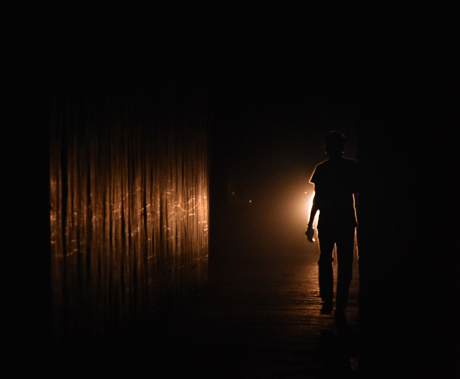 silhouette figure standing alone in infinite corridor surrounded by walls creating sense of being trapped in impossible space