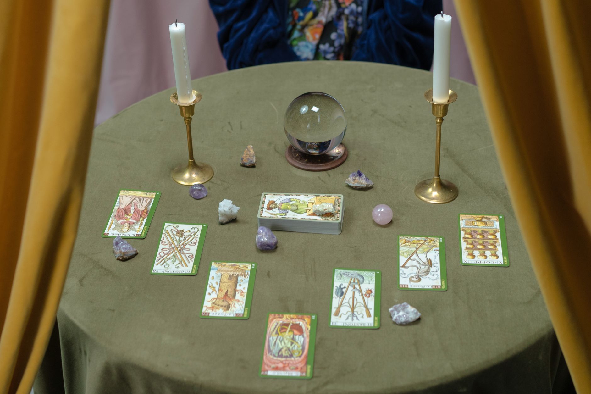 fortune teller crystal ball mystical atmosphere dimly lit room golden light esoteric symbols