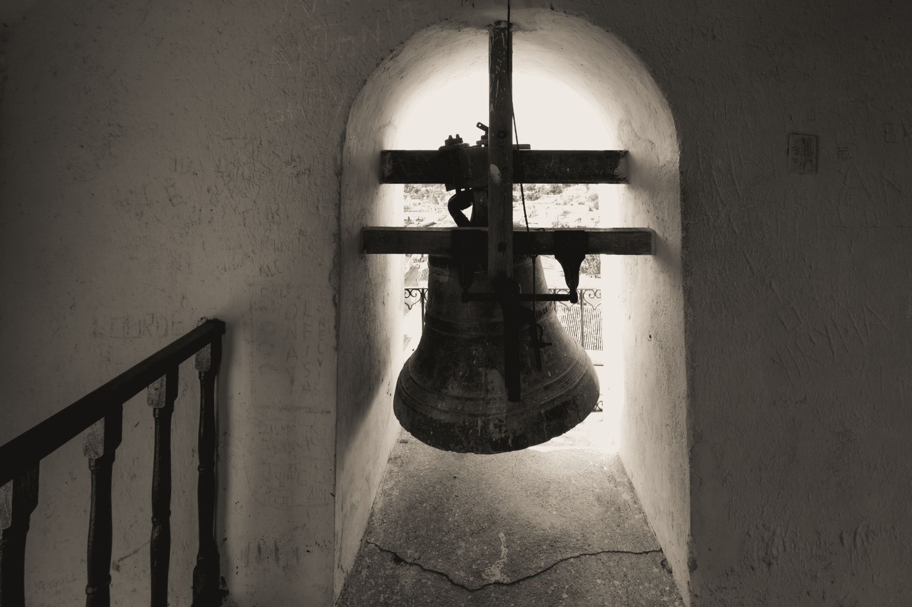 ancient bronze bell hanging in shadow eerie candlelight medieval hall