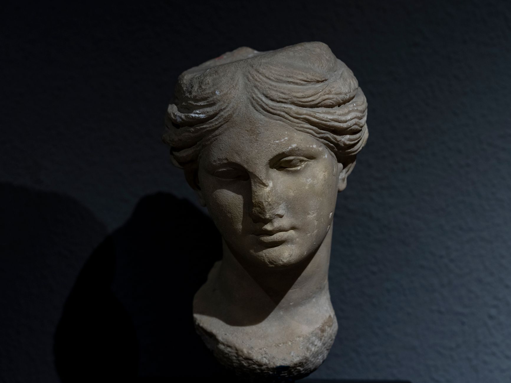 ancient roman marble venus head statue archaeological excavation dramatic light