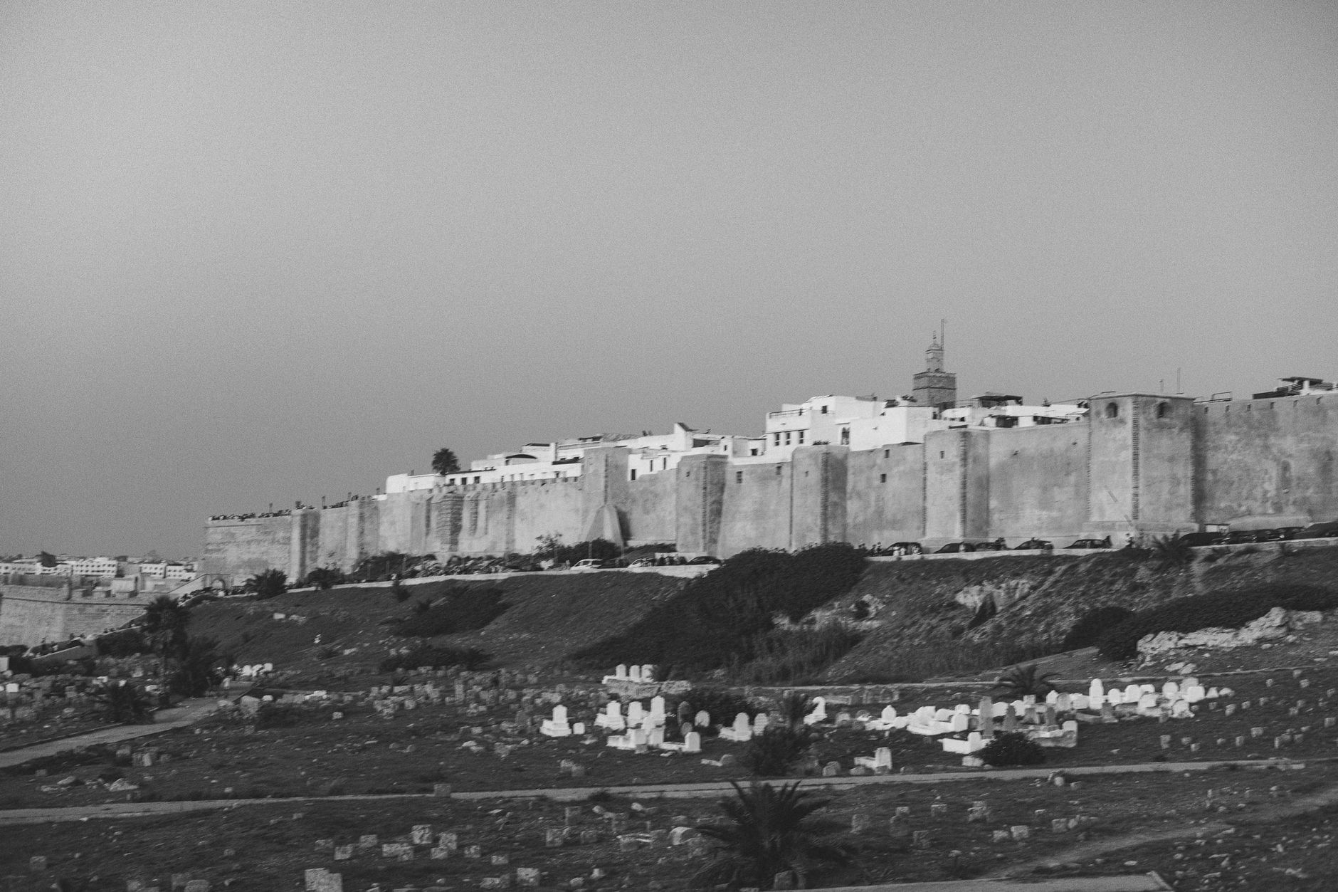 old stone city walls breach with military silhouettes dramatic sepia toned atmosphere